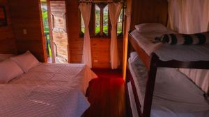 a bedroom with two beds in a wooden cabin at Cabañas/glamping monaco in Santa Rosa de Cabal