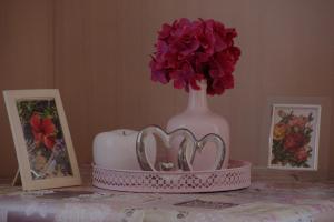 a table with two hearts and a vase with flowers at Ferienwohnung Felicitas Wilthen in Wilthen