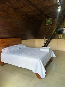 Rio CelesteにあるBungalow Tenorio Mountain Lodgeの白いシーツが敷かれた大きなベッドのある寝室 +3枚の写真