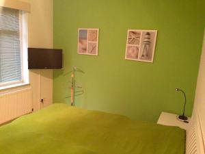 a bedroom with green walls and a bed in it at Ferienwohnung "Humburg", Strand und Stadt in Eckernförde