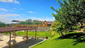 einen Garten mit Pavillon und ein Haus im Hintergrund in der Unterkunft Flat Winterwille Gravatá in Gravatá