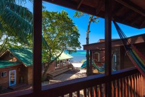 a view of the beach from the porch of a house at The Blue Bahia Resort In Sandy Bay in Coxen Hole