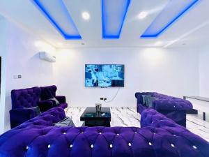 a living room with purple couches and a tv at Fabulous 2 Bedroom Flat in Iju Junction