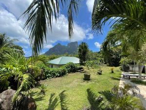 a garden with a bench and mountains in the background at Bora Bora Fare Sophia in Bora Bora