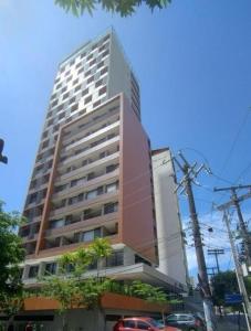 un edificio alto con macchine parcheggiate di fronte di Studio Barra Carnaval a Salvador