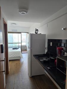 una cucina con frigorifero e una camera con letto di Studio Barra Carnaval a Salvador