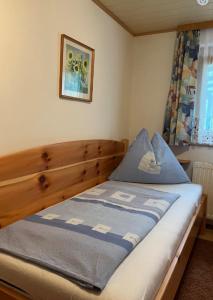 a bedroom with a wooden bed with a blue comforter at Ferienwohnung Burgblick in Sörg