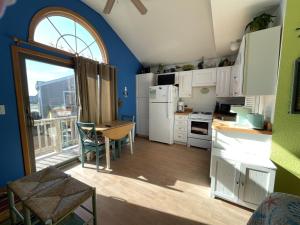 a kitchen with white appliances and a table and a window at NC 12 56821-15 Condo in Hatteras