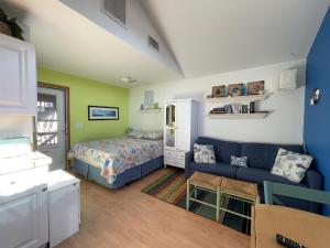 a bedroom with a bed and a blue couch at NC 12 56821-15 Condo in Hatteras +4 photos