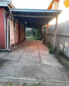 an empty garage with an overhang next to a building at Alojamiento 2 Oriente in Curacautín