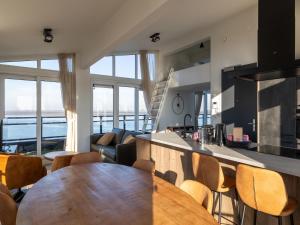 a kitchen and living room with a wooden table and chairs at Penthouse in Sint-Annaland by the Beach in Sint Annaland
