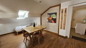 una sala da pranzo con tavolo e un dipinto sul muro di Haus Kreuzeckwiese - FeWo-Waxenstein - Studio Appartment a Garmisch-Partenkirchen