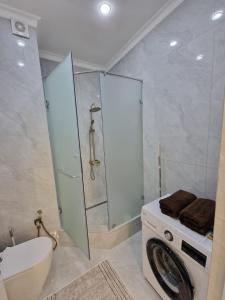 a bathroom with a washing machine and a shower at Новый ЖК Capital City, элитная квартира in Shymkent