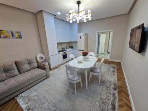 a living room with a table and a couch at Новый ЖК Capital City, элитная квартира in Shymkent +11 photos