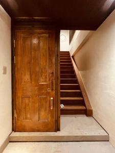 a wooden door in a room with stairs at 2025年OPEN 視点定点 クリエイターズギャラリー inn in Uno