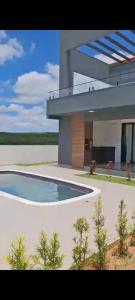 a large house with a swimming pool in front of it at Family home in Paranapanema