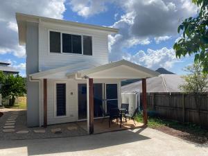 a white house with an awning on a patio at Tallowood Ridge Birdhouse in Mullumbimby