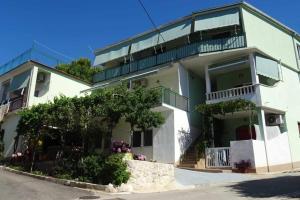 a large white building with a balcony and trees at Apartments with parking space Zivogosce - Blato, Makarska - 23922 in Živogošće