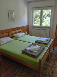 a bedroom with two beds with towels on them at Apartments and rooms by the sea Martinscica, Cres - 23980 in Martinšćica +25 photos