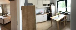 a kitchen with white cabinets and a table in a room at Fewo 1 in Nortorf