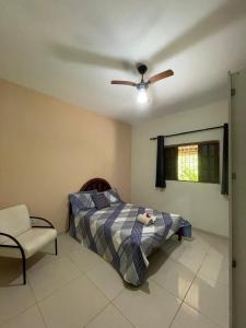 a bedroom with a bed and a ceiling fan at Chácara Gomes - Caiubura - Bertioga in Bertioga +82 photos