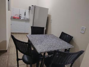 a kitchen with a table with chairs and a refrigerator at Hospedagem aconchego in Pardinho