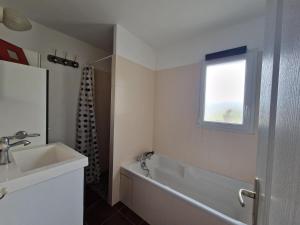 a bathroom with a tub and a sink and a window at Holiday Home in Pleubian near Kermagen Beach in Pleubian +30 photos