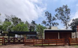 a wooden fence in front of a building at Brisas Rumipal dúplex premium Villa Rumipal in Villa Rumipal