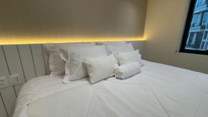 a large white bed with white pillows on it at M N Flats Apartamento Dentro Do Hotel Av Ibirapuera 2534 in Sao Paulo