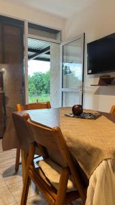 a dining room with a table and a television at Brisas Rumipal dúplex premium Villa Rumipal in Villa Rumipal