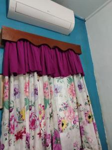 Una ventana con una cortina con flores. en La Casa de la Profe Ticha, en San Nicolás
