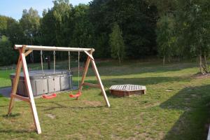 a swing set and a bench in a park at Rieke in Malchow