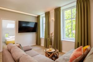 a living room with a couch and a tv at Osterhof Fehmarn - Casa Florale in Fehmarn