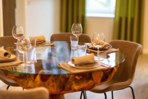 a wooden table with wine glasses and plates on it at Osterhof Fehmarn - Casa Florale in Fehmarn