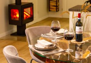 a table with two glasses of wine and a fireplace at Osterhof Fehmarn - Casa Florale in Fehmarn