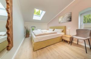 a bedroom with a bed and a chair in it at Osterhof Fehmarn - Casa Florale in Fehmarn