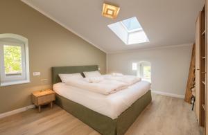 a bedroom with a large bed with a skylight at Osterhof Fehmarn - Casa Florale in Fehmarn +14 photos