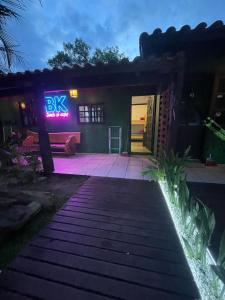 una casa con un'insegna al neon sulla parte anteriore di Hospedaria aconchego 4 a Garopaba 1 altra foto