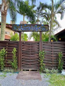 una recinzione di legno con un cartello sopra di Hospedaria aconchego 4 a Garopaba