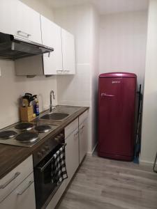 eine Küche mit einem roten Kühlschrank und einer Spüle in der Unterkunft BonnJour - 7 Lounge Apartment in Bonn + 12 Fotos