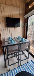a wooden table with blue bowls and plates on it at Cabañas Cerro de Piedra in Pucón