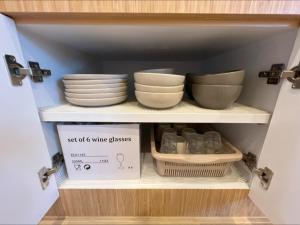 a shelf with bowls and plates and a box on it at Sri House at Supasarnrangsan in Hat Yai