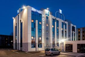 a car parked in a parking lot in front of a building at ibis budget Grigny Centre in Grigny