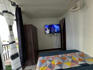 a bedroom with a bed and a tv on the wall at cms 1 bedroom unit in Lapu Lapu City