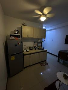 a kitchen with a refrigerator and a ceiling fan at cms 1 bedroom unit in Lapu Lapu City +10 photos