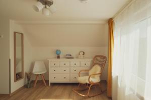 a bedroom with a white dresser and a chair at Haus Hummel Ferienwohnung Liese in Lieske