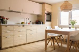 a kitchen with white cabinets and a table and chairs at Haus Hummel Ferienwohnung Liese in Lieske +16 photos