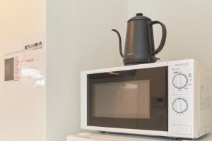 a coffee pot sitting on top of a microwave at Ruygo Setagaya by Tranova in Tokyo