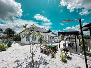 a house on the beach with a palm tree in the sand at Senja Homestay besut POOL in Jertih