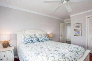 Un dormitorio blanco con una cama y un ventilador de techo. en 2106 Landfall Way, en Seabrook Island